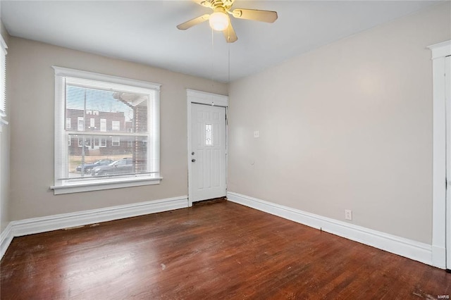 foyer entrance featuring dark wood-style floors, ceiling fan, and baseboards