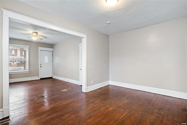 interior space with a ceiling fan, dark wood-style flooring, visible vents, and baseboards