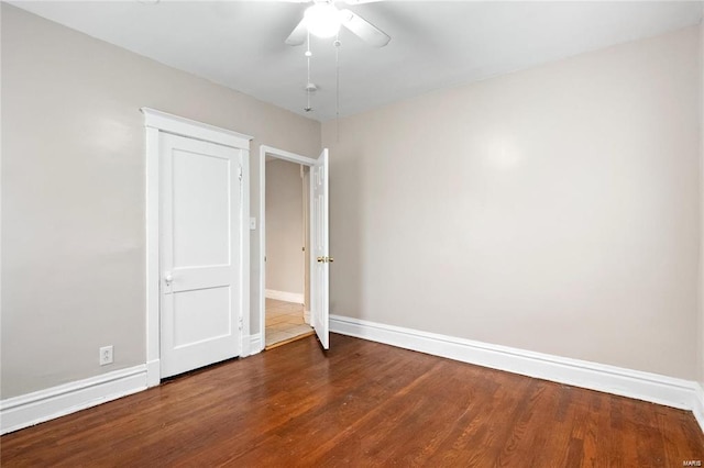 empty room with ceiling fan, baseboards, and wood finished floors