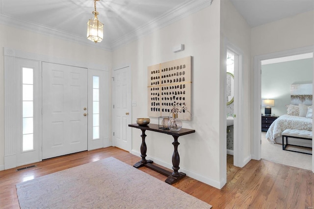 foyer with hardwood / wood-style floors and crown molding