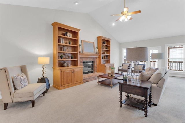 carpeted living room with a brick fireplace, high vaulted ceiling, and ceiling fan