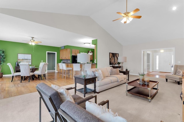 living room with ceiling fan, high vaulted ceiling, and light hardwood / wood-style flooring