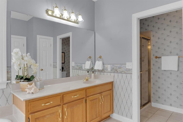 bathroom with tile patterned floors, a shower with door, and vanity