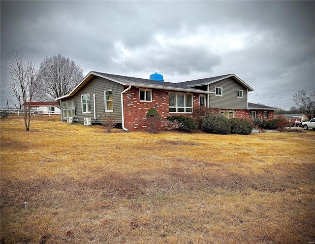 exterior space featuring brick siding and a front yard