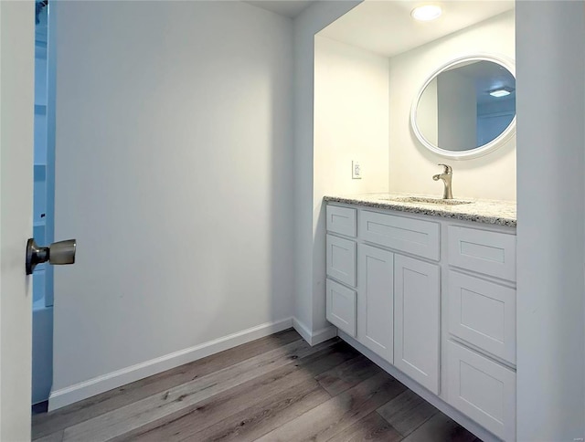 bathroom featuring vanity, wood finished floors, and baseboards