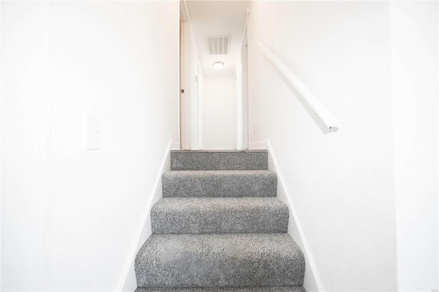 staircase featuring visible vents and baseboards