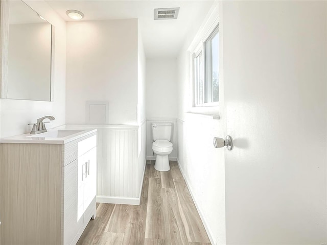 bathroom with visible vents, toilet, vanity, and wood finished floors