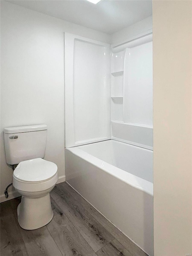 bathroom featuring toilet, wood finished floors, and baseboards