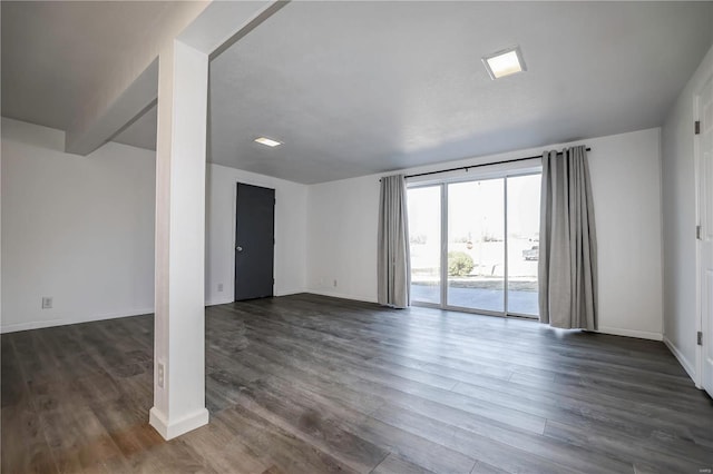 unfurnished room featuring dark wood-style floors and baseboards