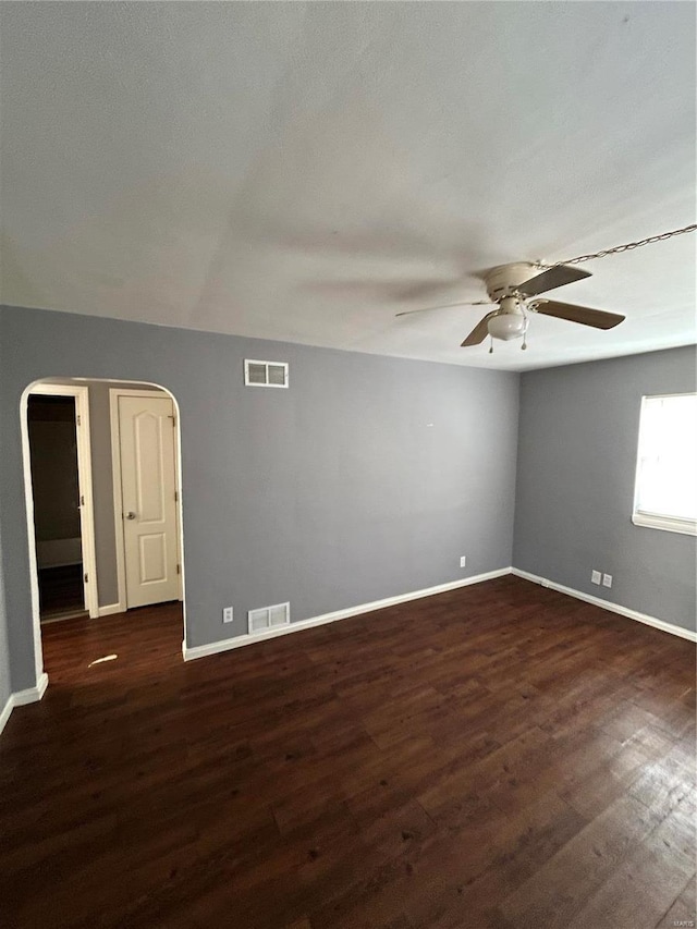 empty room with dark wood-type flooring and ceiling fan