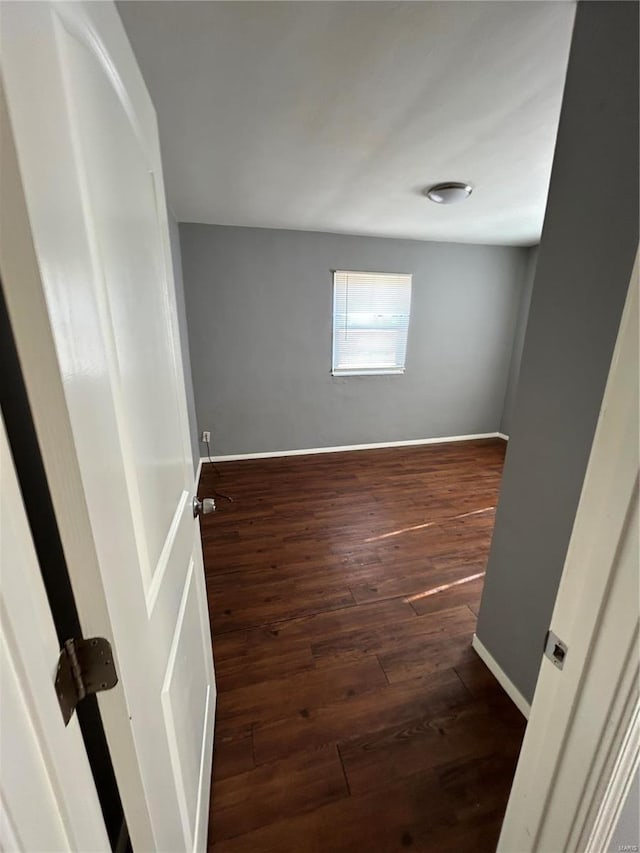 unfurnished room with dark wood-type flooring