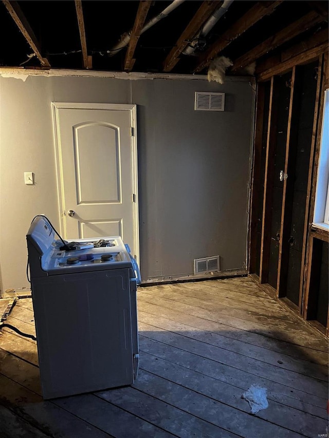 basement featuring washer / clothes dryer, hardwood / wood-style flooring, and visible vents