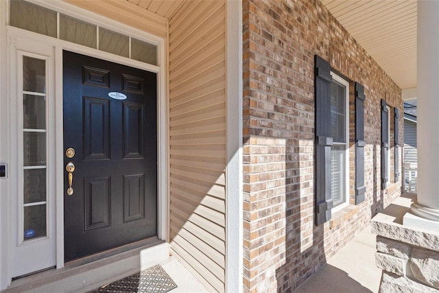 doorway to property with brick siding