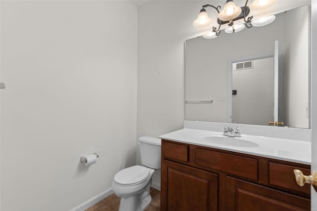 bathroom with a chandelier, tile patterned flooring, toilet, vanity, and visible vents