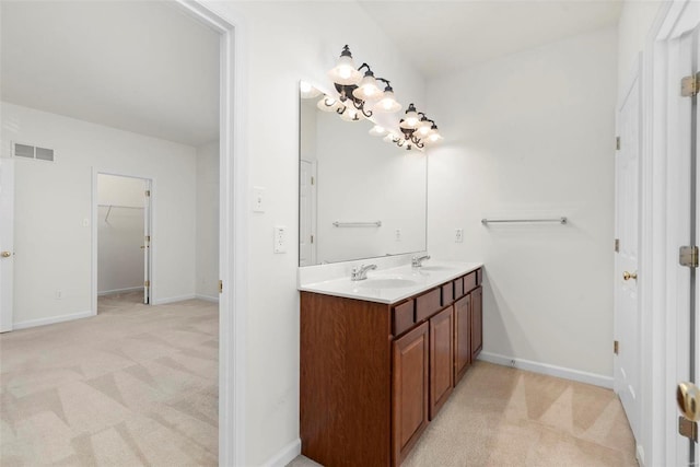 bathroom with visible vents, a sink, baseboards, and double vanity