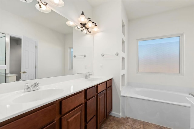 bathroom featuring a garden tub, double vanity, and a sink