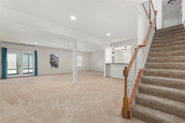 basement with a healthy amount of sunlight, recessed lighting, stairs, and light colored carpet