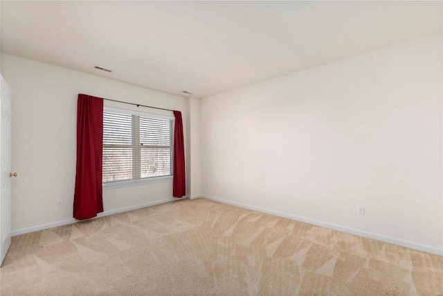 unfurnished room with baseboards, visible vents, and light colored carpet