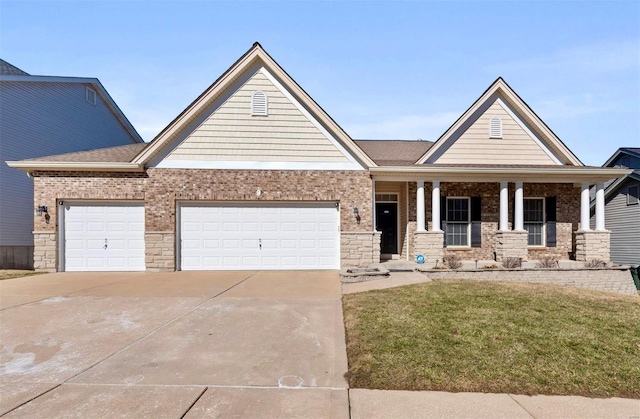 view of front of property with a garage, driveway, brick siding, a porch, and a front yard