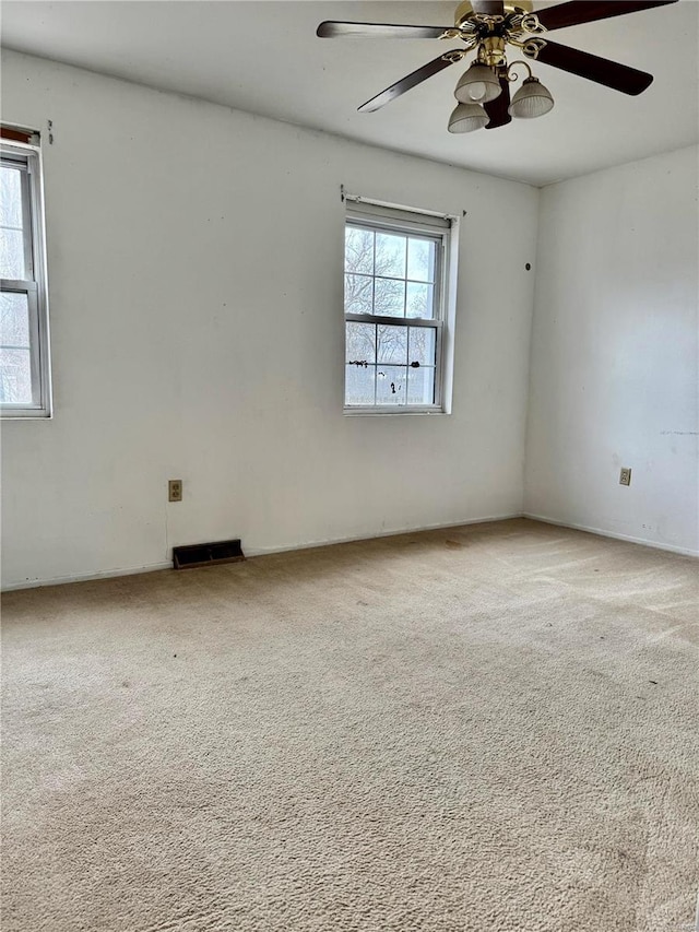 carpeted spare room featuring ceiling fan