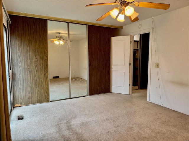 unfurnished bedroom with ceiling fan and a closet