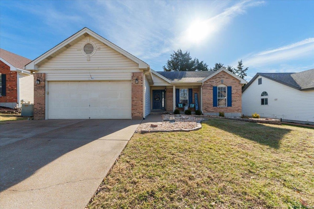 single story home featuring a garage and a front lawn