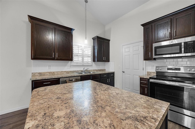 kitchen with sink, appliances with stainless steel finishes, hanging light fixtures, backsplash, and dark brown cabinets