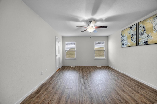 empty room featuring dark hardwood / wood-style flooring and ceiling fan