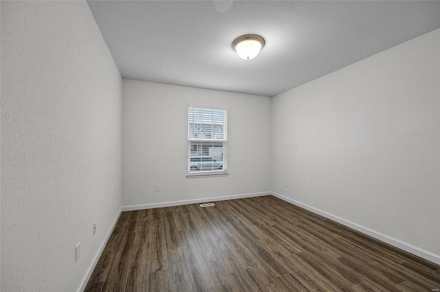 spare room with dark hardwood / wood-style flooring