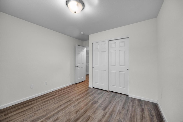 unfurnished bedroom featuring hardwood / wood-style flooring and a closet