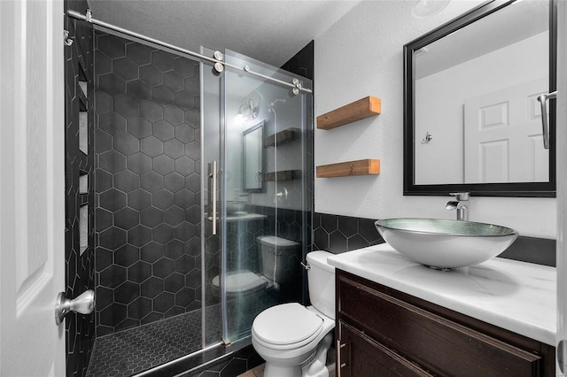 bathroom featuring vanity, toilet, a shower with door, and tile walls