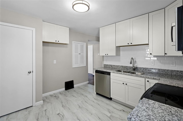 kitchen featuring stainless steel appliances, white cabinetry, sink, and tasteful backsplash