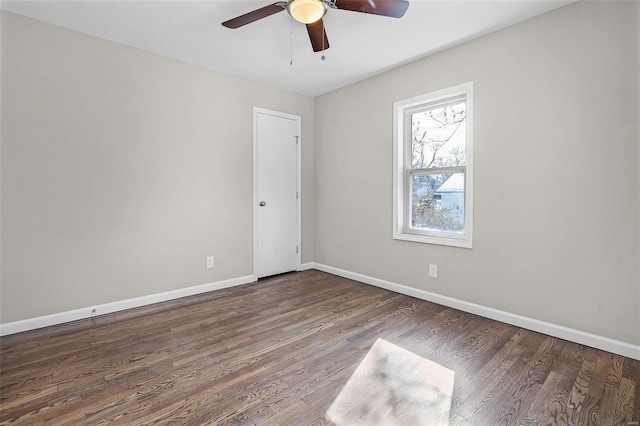 empty room with ceiling fan and dark hardwood / wood-style flooring