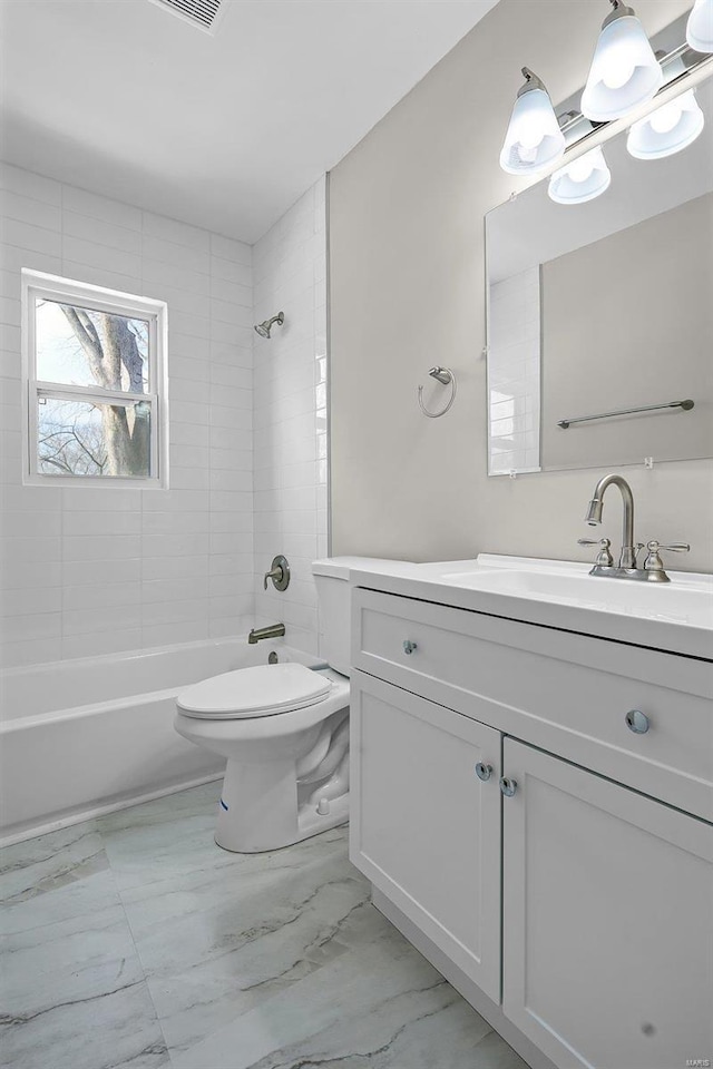 full bathroom with vanity, toilet, and tiled shower / bath combo