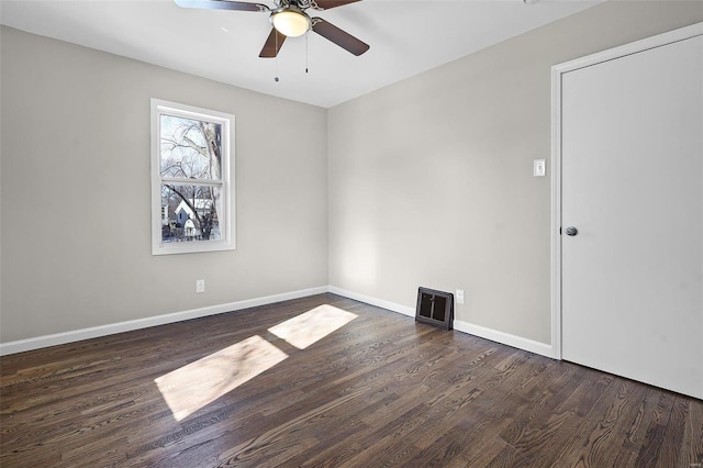 spare room with dark wood-type flooring and ceiling fan