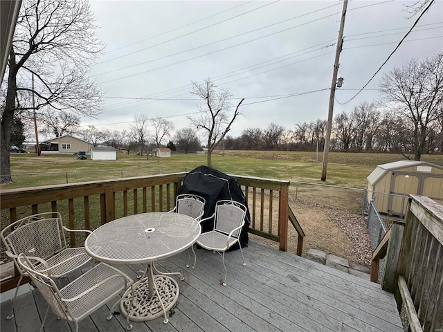 deck with a yard, grilling area, and a storage unit