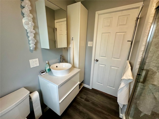 bathroom featuring vanity, an enclosed shower, wood-type flooring, and toilet