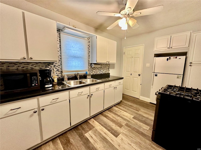 kitchen with white cabinetry, sink, and black appliances