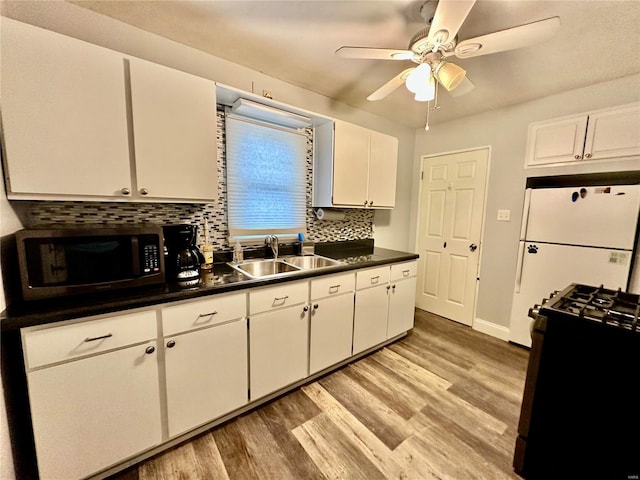 kitchen featuring white cabinetry, sink, light hardwood / wood-style floors, and black range with gas cooktop