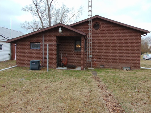 rear view of property with a yard and central AC