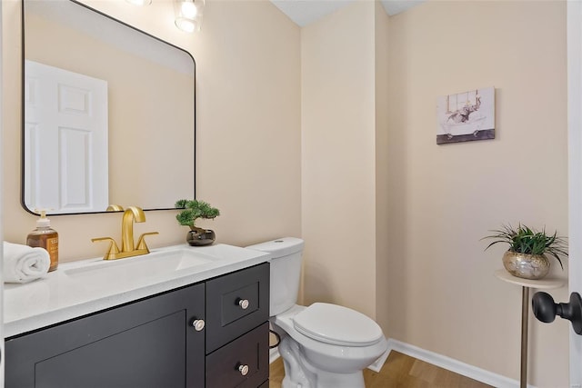 bathroom with vanity, toilet, and wood-type flooring