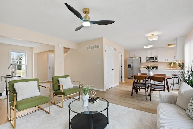 living room featuring light hardwood / wood-style floors and ceiling fan