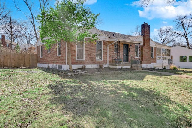 view of front of property featuring a front yard, brick siding, fence, and a chimney