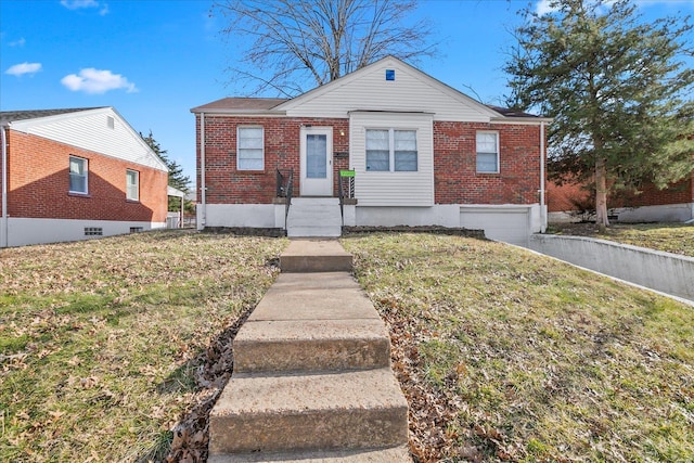 bungalow-style house with a garage, a front yard, brick siding, and aphalt driveway