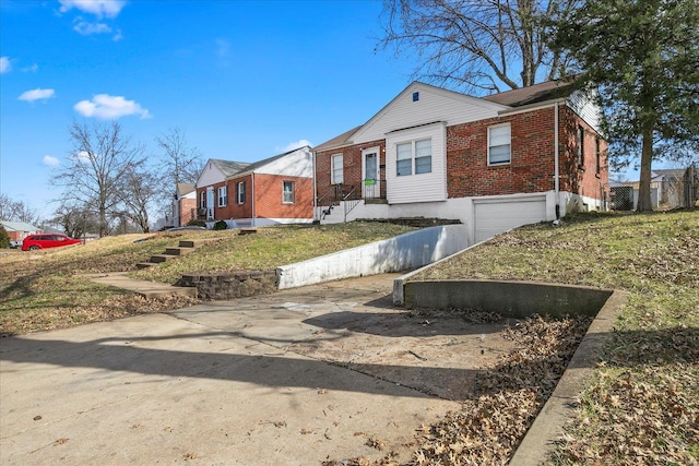 view of front of home featuring driveway, brick siding, and an attached garage