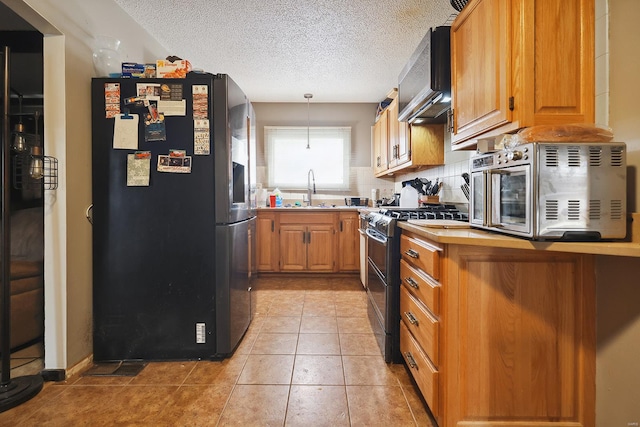 kitchen featuring sink, backsplash, hanging light fixtures, light tile patterned floors, and stainless steel appliances