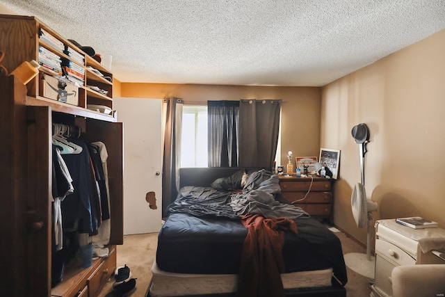 bedroom featuring light colored carpet, a closet, and a textured ceiling