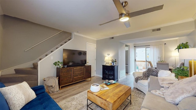 living room featuring ornamental molding, ceiling fan, and light wood-type flooring