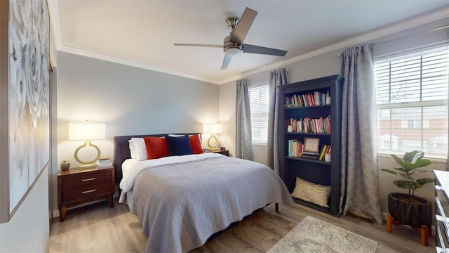 bedroom with crown molding, ceiling fan, and light hardwood / wood-style floors