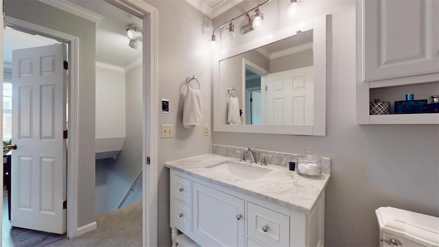 bathroom featuring vanity, ornamental molding, and toilet